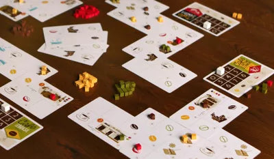 Players managing plantations and roasting beans in Cafe, the strategic coffee card game from Portugal.
