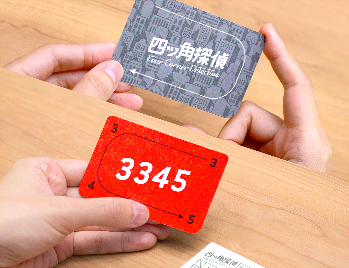 Players using their fingertips to examine cards in Four Corner Detective during a deduction round.