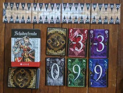 All components of Schadenfreude, including trick-taking cards and rulebook.