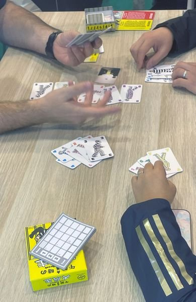Players mid-game in 1 A.M. Jailbreak with cards on the table